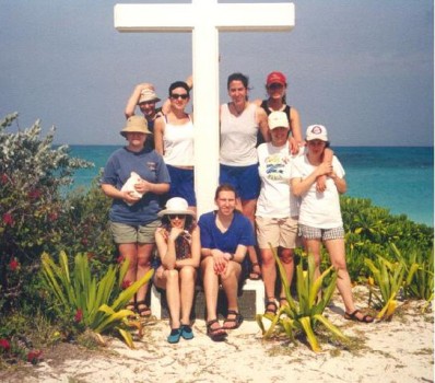 Students pose next to a cross on the beach