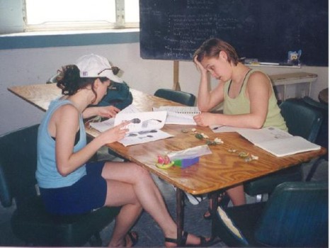 Two students review papers at a table.
