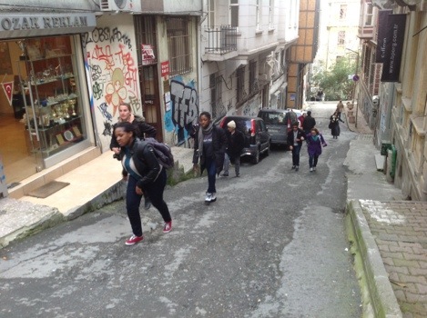 Student walking up steeply inclining street