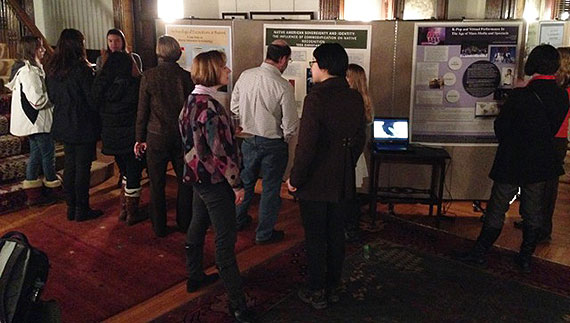 Colgate faculty members speak to students about their posters inside Merrill House