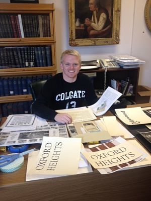 Jerod Gibson-Faber '16 reviews artifacts for his upcoming exhibit on the history of sports in Oneida County.