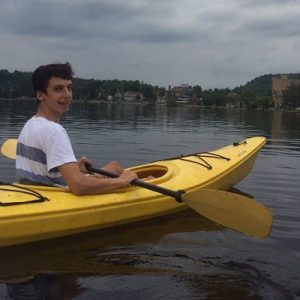 Jared Collins in a yellow kayak on an Adirondack lake
